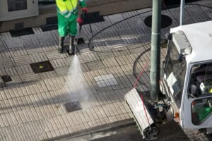 Sweeper washing a street sidewalk with high pressure water jet machine
